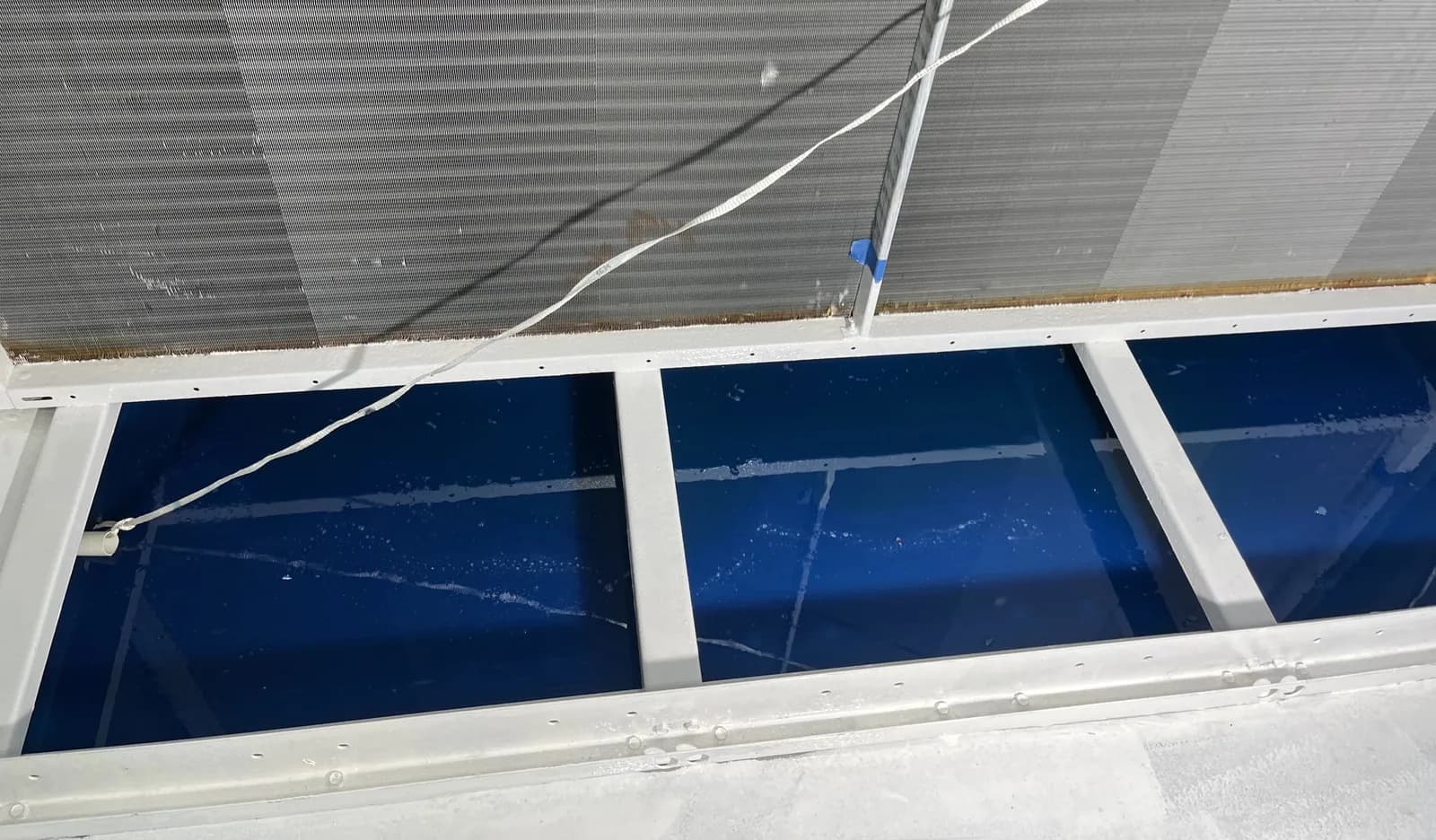 Condensate pans after resurfacing, with drainage verified and coating cured